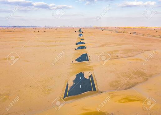 142039645-vue-aérienne-d-une-route-à-moitié-désertique-ou-d-une-rue-avec-une-dune-de-sable-dans-la-ville-de